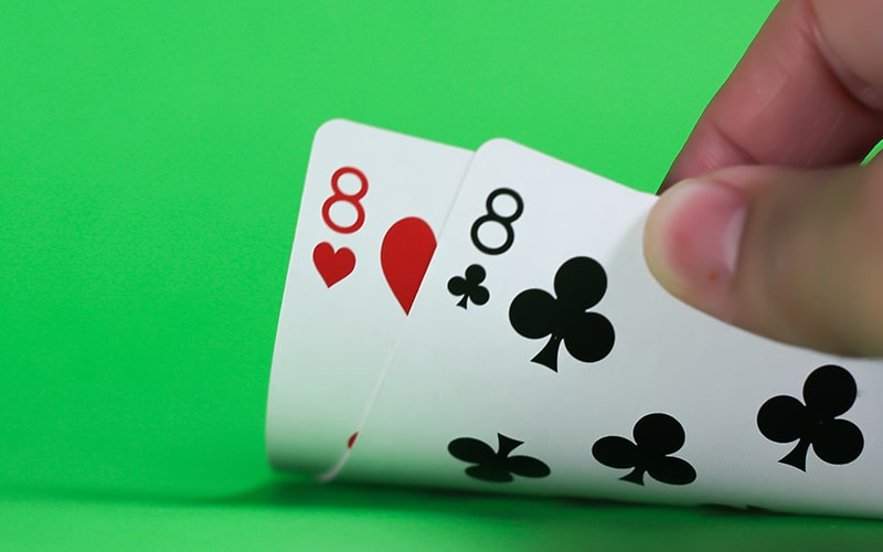 Par osmica u ruci za stolom za blackjack